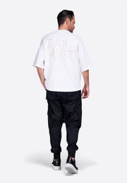 Model wearing white short tassel T-shirt with premium cotton East Vibe